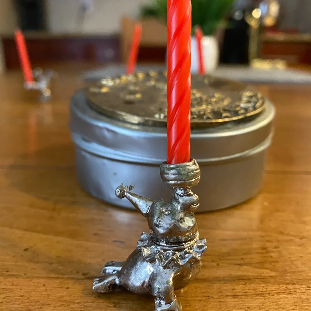 Set of animal candle holders stored in a metal tin.